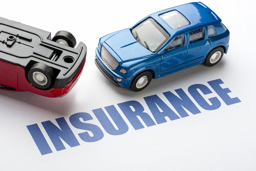 Concept photograph for Car Insurance with two toy cars facing each other and one is upside down