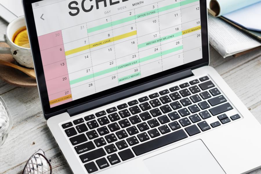 Concept photograph Appointment Schedule. Laptop showing online calendar with Schedule