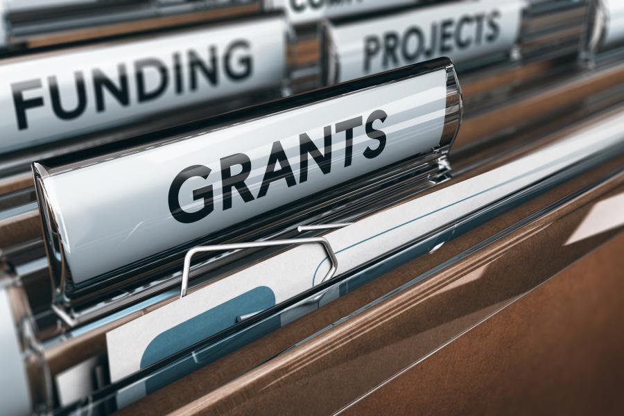 Concept photograph of funding.  View of brown folders, with focus on grants label.