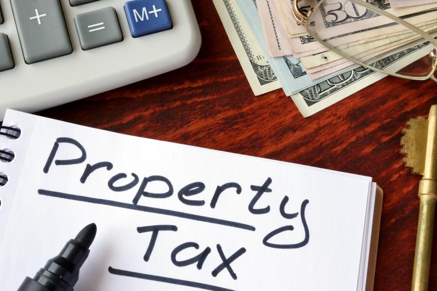 Concept photograph for Property Tax written in a notebook and calculator.