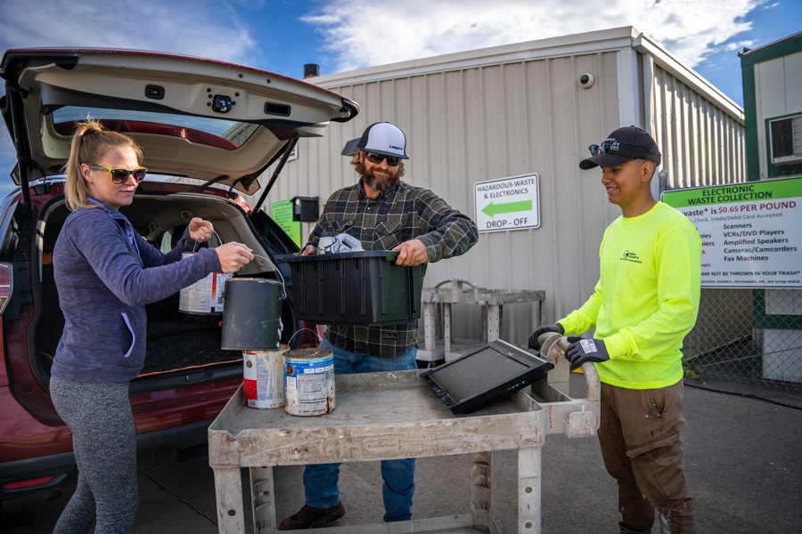 A man and woman drop off their old paint at the Mesa County Hazardous Waste Collection Facility