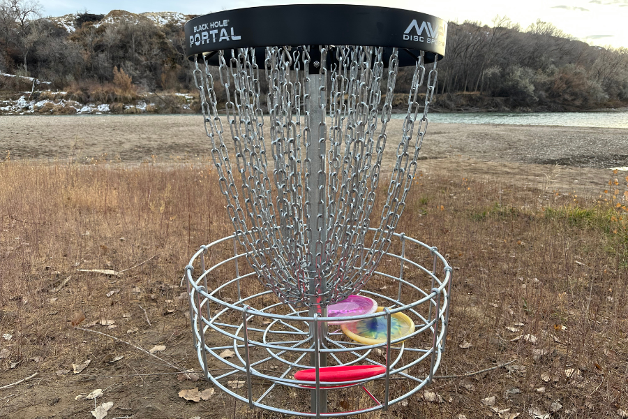 A disc golf basket with disc golf discs