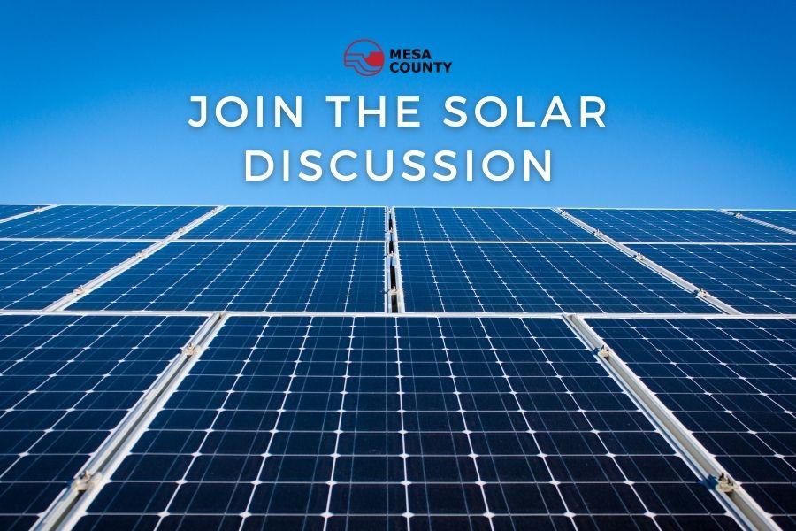Solar panels with white text above them reading "JOIN THE SOLAR DISCUSSION" and a red and black Mesa County logo above the text. 