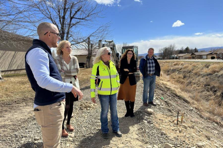 Five Mesa County leaders stand on gravel near a current Public Works project. 