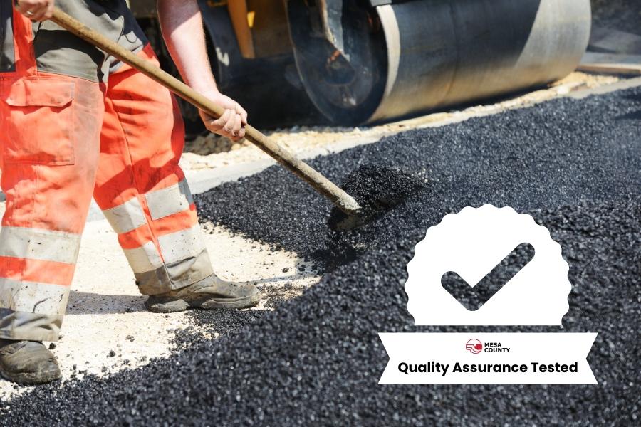 Road construction worker moving asphalt with white check mark element reading, "Quality Assurance Tested." 
