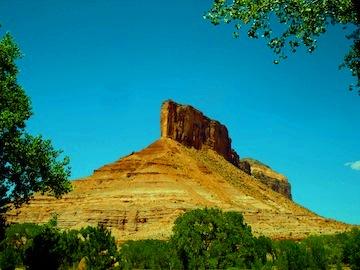 Photograph of the Palisade which is a nice red rock formation rising over 2000 feet above the small community of Gateway in western Colorado