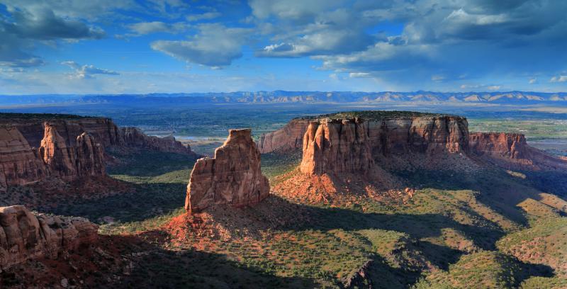 Photograph taken from the Colorado National Monument that shows part of the mountain formations, the Grand Valley and the desert mountains and cliffs that make up the Bookcliffs that stretch almost 200 miles across western Colorado and eastern Utah