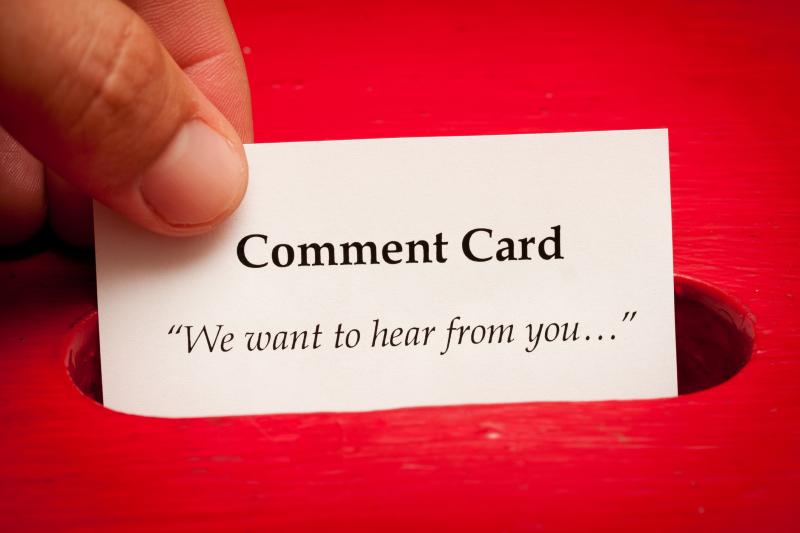 Photograph of Comment Card with "We want to hear from you..." printed on it and being dropped into a red box