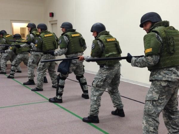 Photograph of Special Operations Response Team in a line training with batons