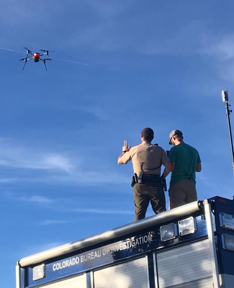 Photograph of Deputies flying a drone and standing on the top of vehicle
