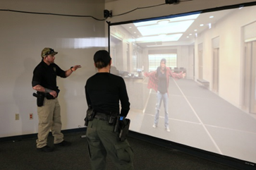Photograph of deputies in Shooting Training with screen showing a person standing with their hands up