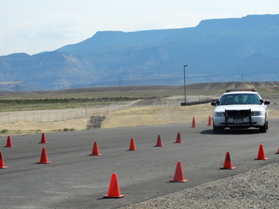 Photograph of a Mesa County Sheriff's vehicle on driving course at Colorado Law Enforcement Training Center driving through cones on track