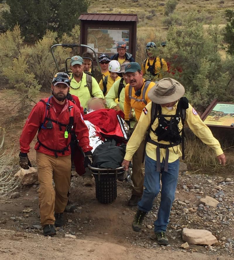 Photograph of Search and Rescue team hiking out with victim on a wheeled stretcher