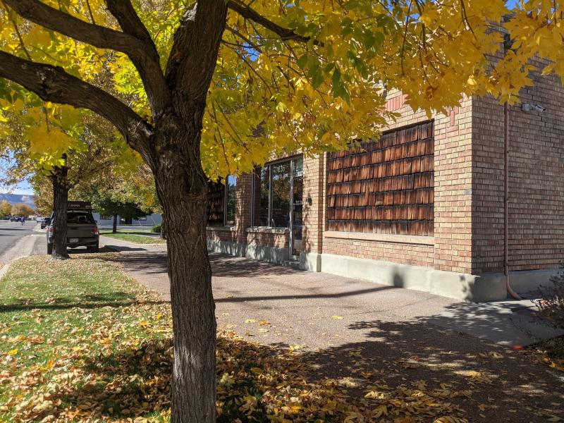 Photograph of the outside of the Bridger Facility building with a tree in fall colors