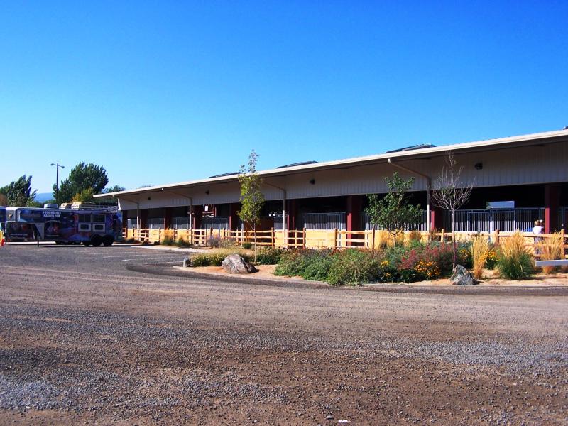 Photograph of exterior of stables with parking lot