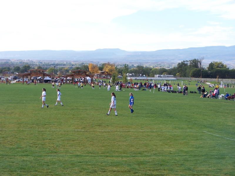 children in uniform playing soccer games on the grassy field