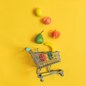 mini shopping cart tipped over with fruit spilling out
