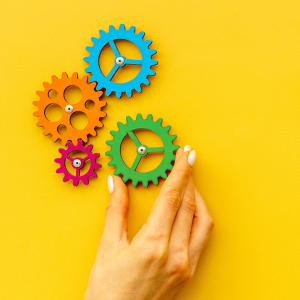 4 colors of wheeled cogs on a yellow background