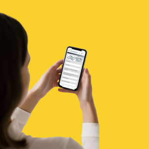 woman holding a phone with a yellow background