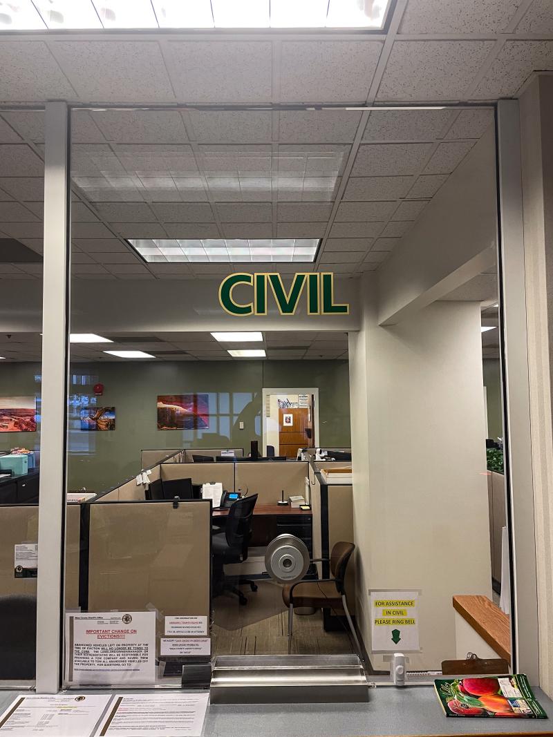 A glass window has the word CIVIL on it to denote the Civil Services desk at the Mesa County Sheriff's Office.