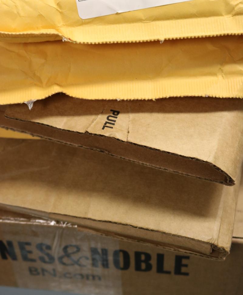 Two yellow packages sit atop three brown packages as part of the inmate mail at the Mesa County Detention Facility.