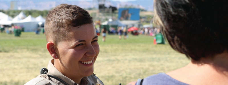 Mesa County Sheriff's Office Deputy Simon has a broad smile on her face as she talks to a woman during Country Jam.