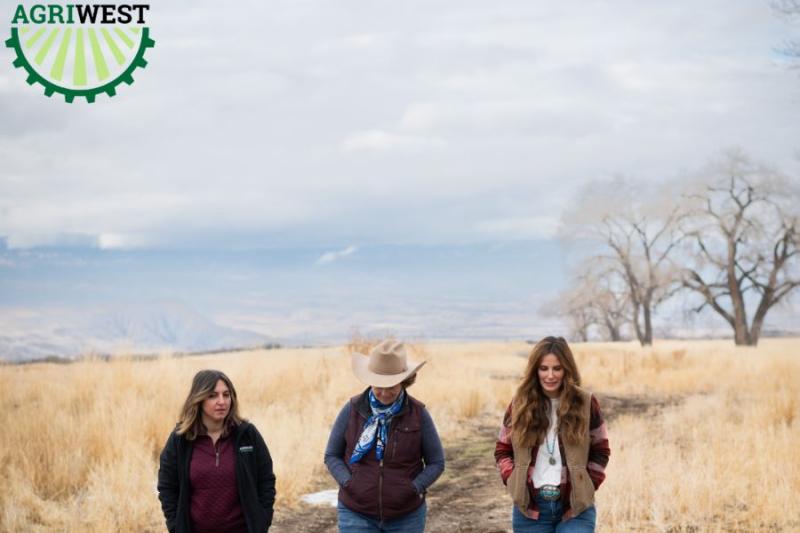 Three women walk toward camera on open space path with green AGRIWEST logo in the top left. 