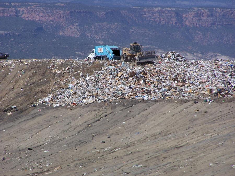 Photograph of a large pile of trash with trash truck and Front Shovel Excavator moving trash around