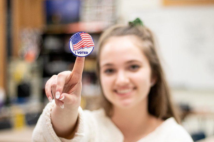girl holding I Voted sticker