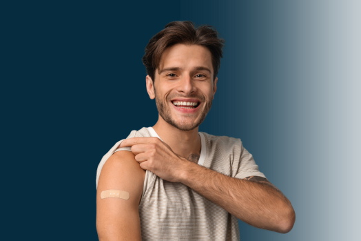 Young adult man lifting his sleeve to show a bandage, presumably from getting a vaccine.